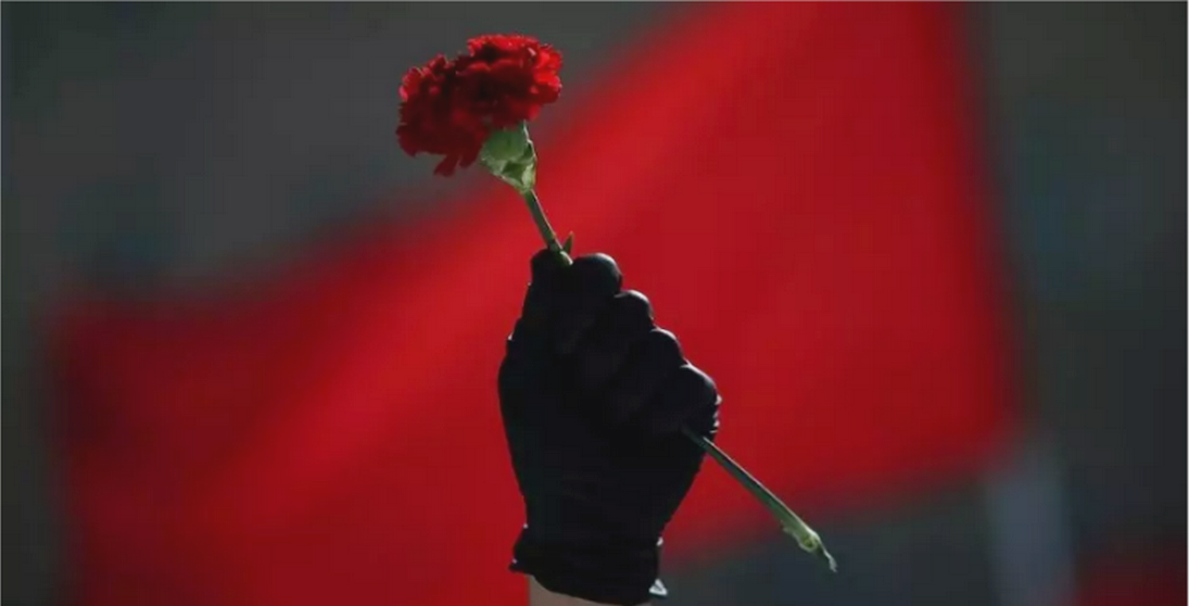 Un miembro del sindicato griego, PAME, levanta un clavel durante una manifestación que conmemora el Primero de Mayo en Atenas, Grecia. 1 de mayo de 2020. / Foto: Alkis Konstantinidis ( Reuters)